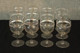 A set of twelve early 20th century wine glasses with acid etched decoration. H.12cm (each).