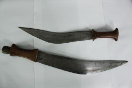 Two Nepalese Gurkha Kukri sheathed knives. Early twentieth century. The largest of the pair measures