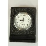 A Swiss made 8 day clock set in a pen rest with delicate floral relief. L.10 x W.8 cm.