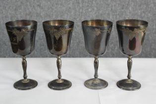 Four engraved silver goblets with vine and grape design. Hallmarked and each 14 cm high. With a