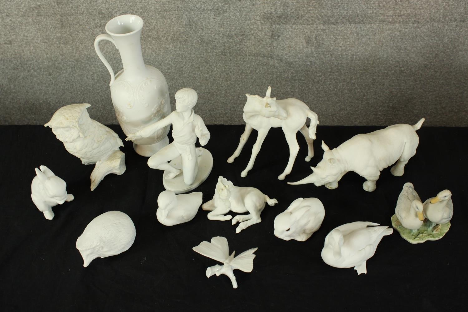 A collection of twelve pieces of mixed porcelain. A mix of animals, a jug and a child. The largest