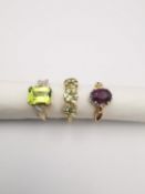 Three 20th century 9 carat gold gem-set rings, a peridot and and white stone flanked solitaire ring,