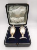 An Edwardian leather cased silver salt and pepper set. Hallmarked:D&F for Deakin and Francis,