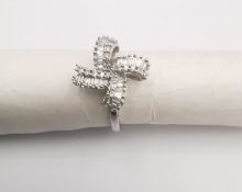 A 9ct white gold diamond set bow design ring , set with twenty eight rectangular baguette cut