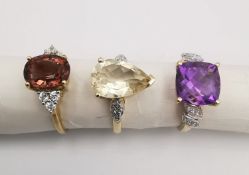 Three 20th century 9 carat gold gem-set rings, a tourmaline and white topaz flanked solitaire