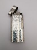 A white metal textured Dunhill lighter. Stamped 'Made in England', 'A.D' and a serial number '
