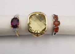 Three 20th century 9 carat gold gem-set rings, a yellow stone dress ring, a orange garnet three
