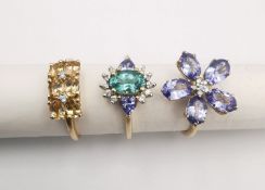 Three 20th century 9 carat gold gem-set rings, a tanzanite and diamond flower ring, a topaz dress