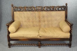 Sofa. bergere style carved and caned fitted with loose cushions. H.86 W.140cm.