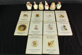 A collection of Beatrix Potter books and porcelain characters including Peter Rabbit and Jeremy