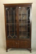 A 20th century Georgian style twin glazed door display cabinet, the doors opening to reveal