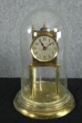 A brass anniversary clock set in a glass dome. With the makers mark on the back of the movement. H.
