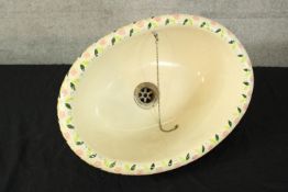 A deep and well decorated sink basin. With hand painted floral decoration around the rim. Maybe