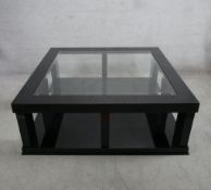 A contemporary square black painted and glass inset coffee table. H.42 W.120 D.120cm