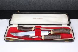 A Stag handled carving set. Made in Sheffield. The largest measures L.40cm.