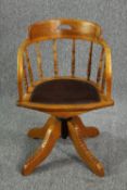 A late 19th century revolving oak desk chair with leather upholstery.
