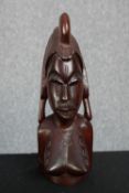 A hardwood carving of an African female in a decorative and detailed headdress. H. 29cm.