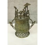A bronze Ashanti ceremonial vessel. The lid populated with six figures, the largest is seated