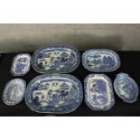 A collection of blue and white platters. Decorated with traditional Chinese pagoda and trees. And