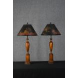 A pair of turned Chinese style lamps with hand painted shades. The shades feature pagodas and a
