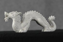 A Chinese porcelain dragon. Twentieth century. H.10 x W.24 x D.9 cm.