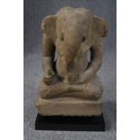 An 11th or 12th century Cambodian carved sandstone statue of Ganesha in the lotus position from