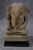 An 11th or 12th century Cambodian carved sandstone statue of Ganesha in the lotus position from