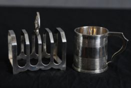 A silver toast rack and cup with a combined weight of 244g. With hallmarks of the crown and a 'P'.