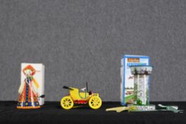 A collection of three Russian tin litho wind up toys. To include an aircraft carousel, doll and car.
