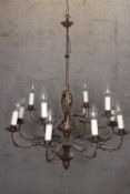 A large foliate chandelier with twelve branches of lights and decorative trunk. Complete with