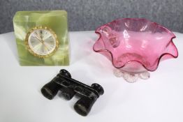 A group of collectables. An onyx clock, cranberry glass bowl and opera glasses. The largest with a