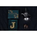 A solid brass paperweight in the shape of a 'J' and two others. A miniature hardwood elephant and