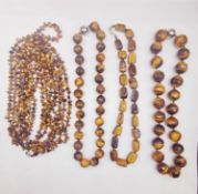Four 20th century knotted tigers eye bead necklaces, including a multi strand polished pebble bead