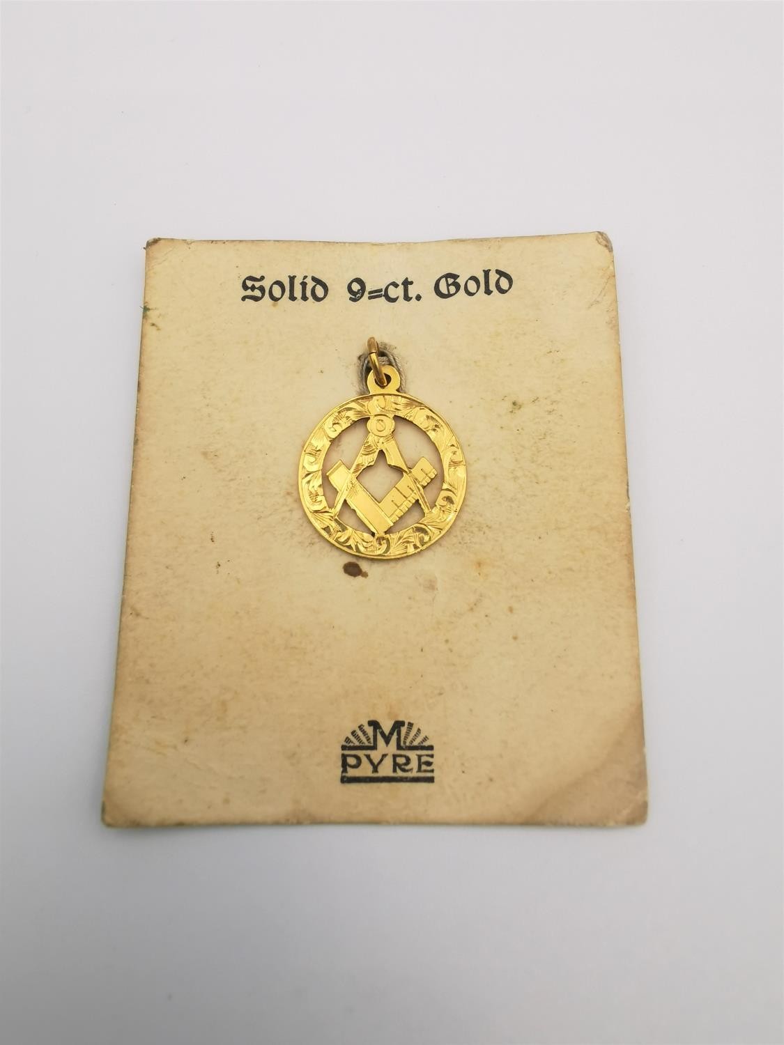 A 9ct yellow gold pierced and engraved masonic pendant with square and compasses. Stamped 9ct.