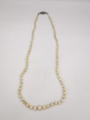 A string of knotted cultured pearls with a diamond and white gold clasp, engraved detailing to the