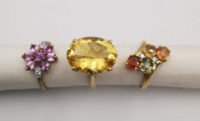 Three 20th century 9 carat gold gem-set rings with certificates. A Citrine solitaire ring, a