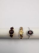 Three 20th century 9 carat gold gem-set rings with certificates. A garnet three stone ring, a red