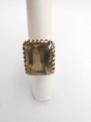 A 9ct rose gold smokey quartz dress ring, set with a rectangular mixed cut smokey quartz with an