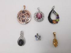 Six silver gem set pendants, a star ruby and white topaz cluster pendant, a Citrine marquise