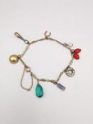 A yellow metal charm bracelet with safety chain. Charms include a 9ct and enamel RAF epaulette,