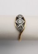 An Edwardian 18ct yellow gold and platinum three stone diamond ring. The ring is set centre with a