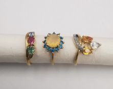 Three 20th century 9 carat gold gem-set rings, with certificates. A rainbow sapphire and diamond