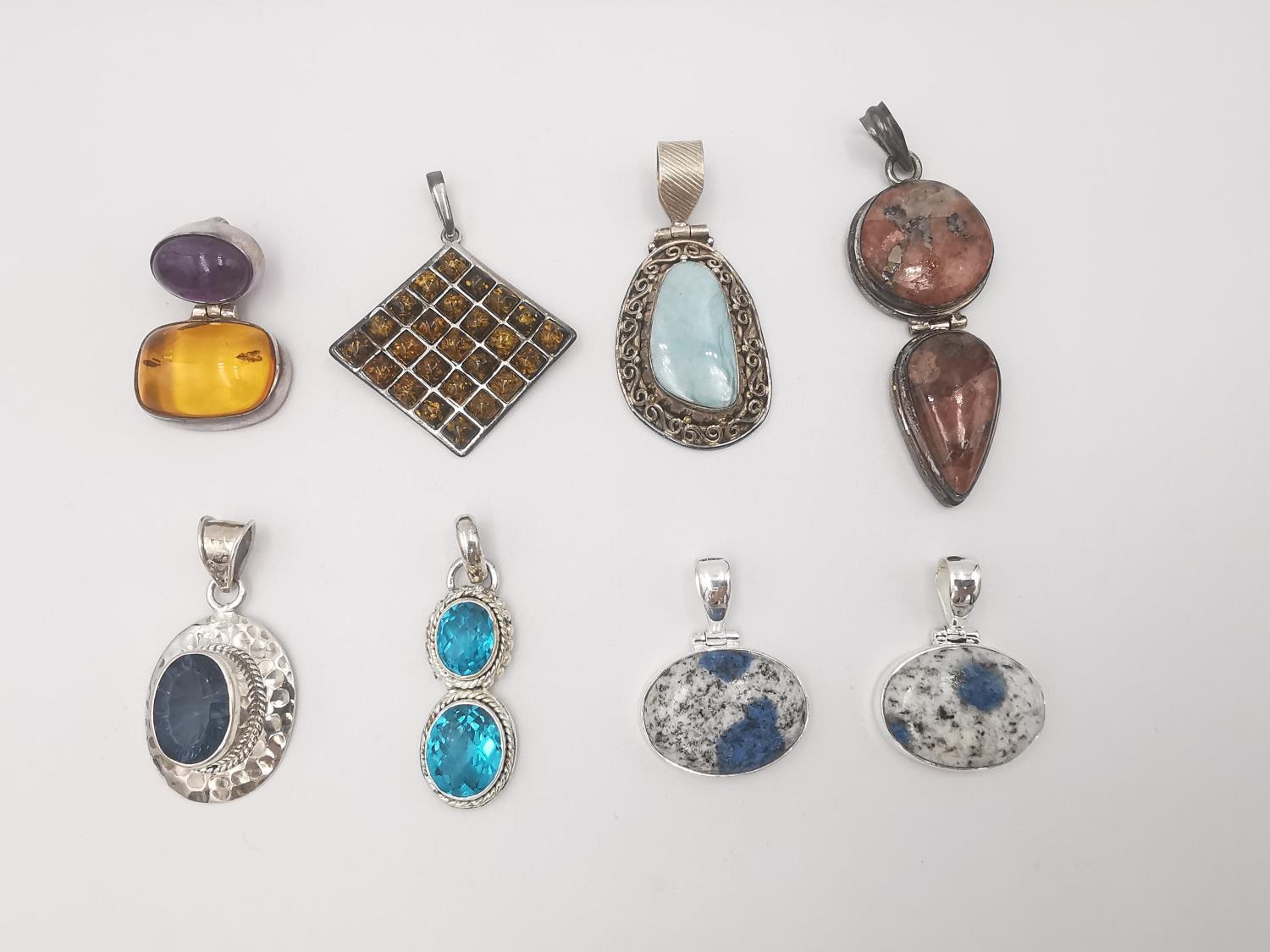 Eight silver gem set pendants, set with amber, amethyst, apatite and Jasper. Various designs and all