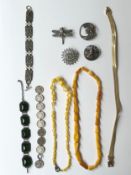 A collection of costume jewellery, including a green paste articulated bracelet, a pewter