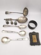 A collection of silver to include silver three thimbles, a ladle, four spoons, a picture frame