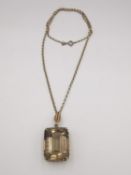 A statement smokey quartz pendant in yellow metal setting with a 10 inch fine trace 9ct yellow