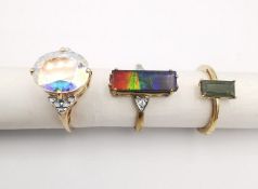 Three 20th century 9 carat gold gem-set rings, an ammolite triplet and white topaz flanked solitaire