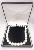A boxed statement round white cultured pearl necklace with silver magnetic clasp. Pearls measure 1.