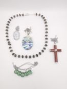 Five gem set silver pendants and necklaces. A coral cross on silver trace chain, a green stone set