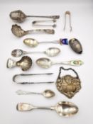 A collection of silver cutlery and other items, a silver repoussé drinks label, a tea strainer,